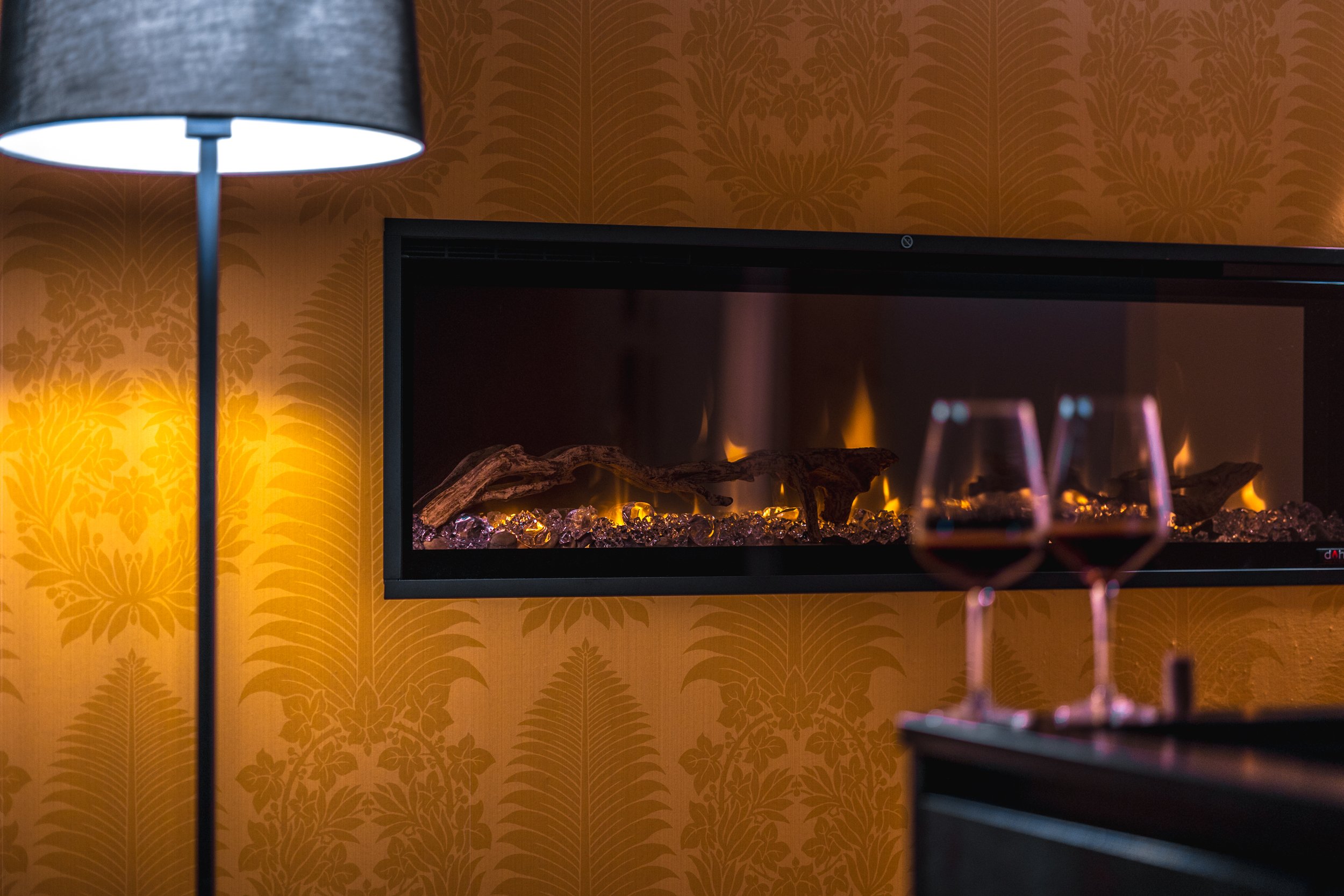 Zwei Weingläser vor einem Kamin - Oberplunerhof