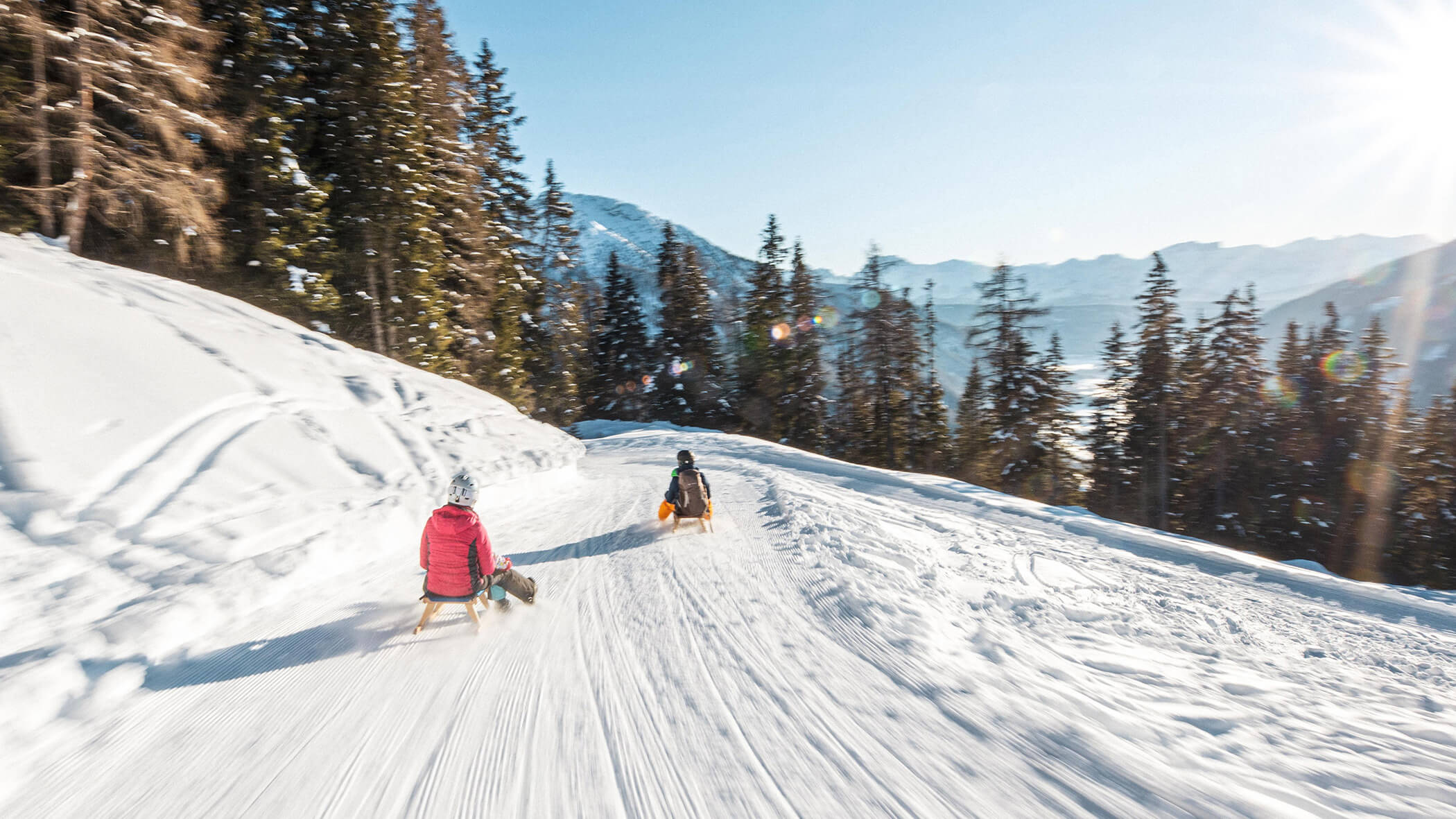 Zwei Personen rodeln die Rodelbahn hinunter - Oberplunerhof