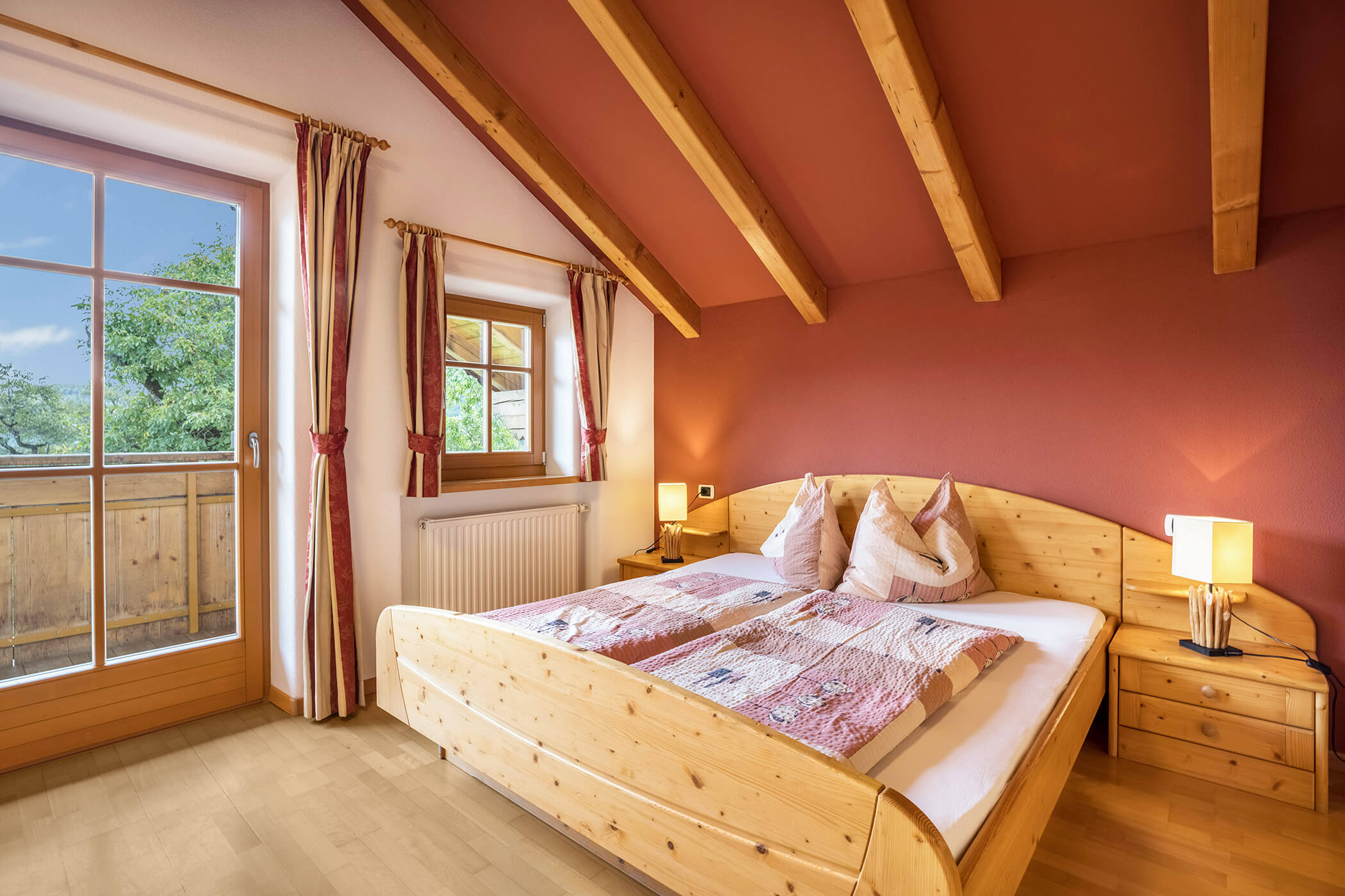 Doppelbett im Apartment Kronplatz mit Blick auf den Balkon - Oberplunerhof