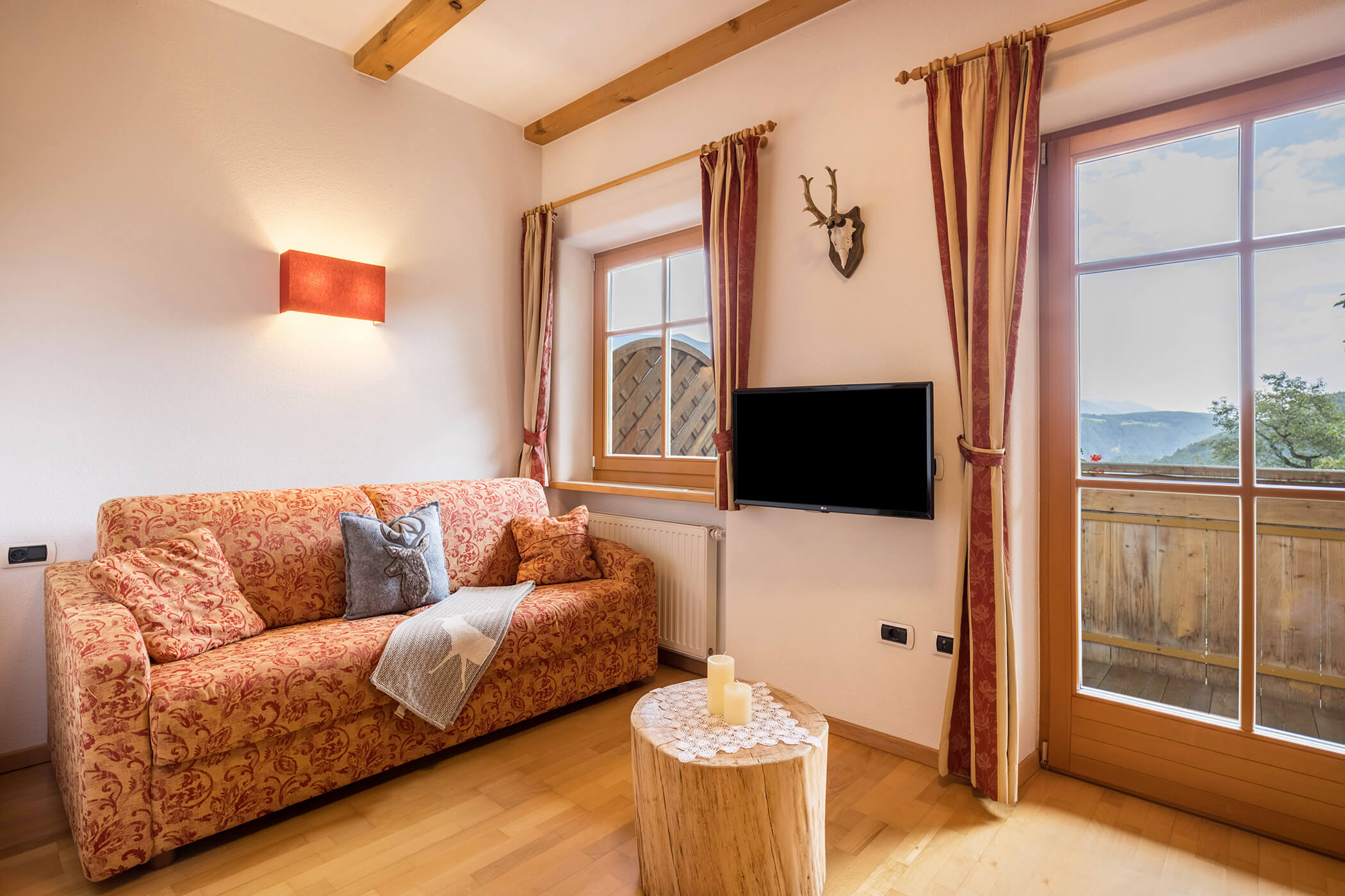 Wohnzimmer im Apartment Kronplatz mit Sofa, TV und kleinem rundem Tisch - Oberplunerhof