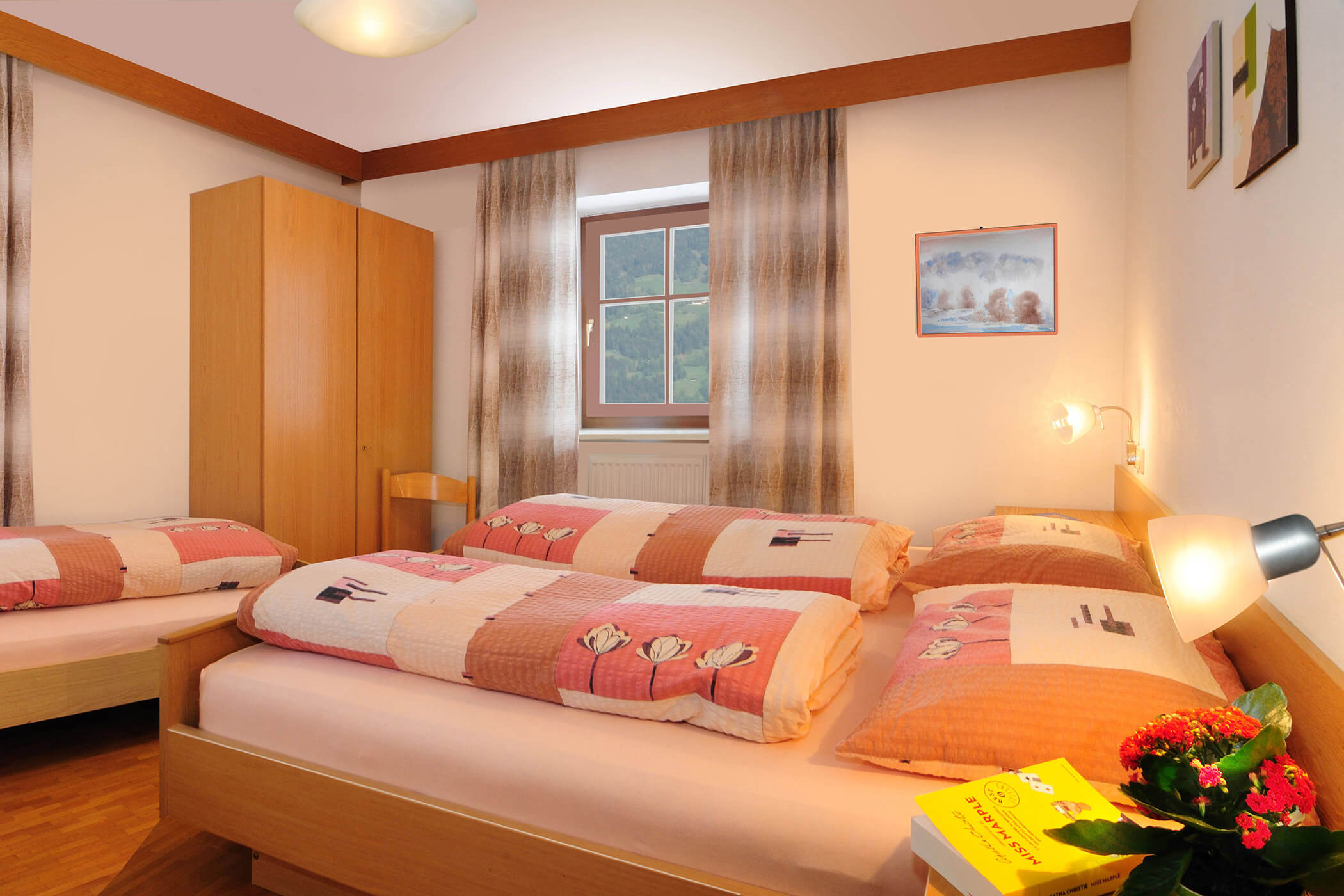 Schlafzimmer im Apartment Panorama am Radmüllerhof mit Doppelbett, Einzelbett und Holzschrank - Oberplunerhof
