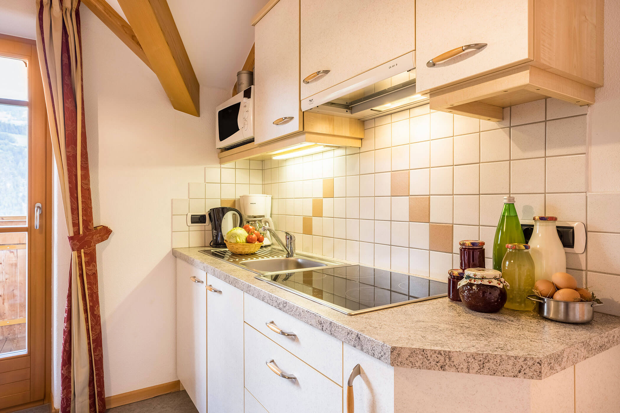 Kochnische vom Apartment Bruneck mit verschiedenen Säften, Marmelade, frischer Milch und Eiern - Oberplunerhof