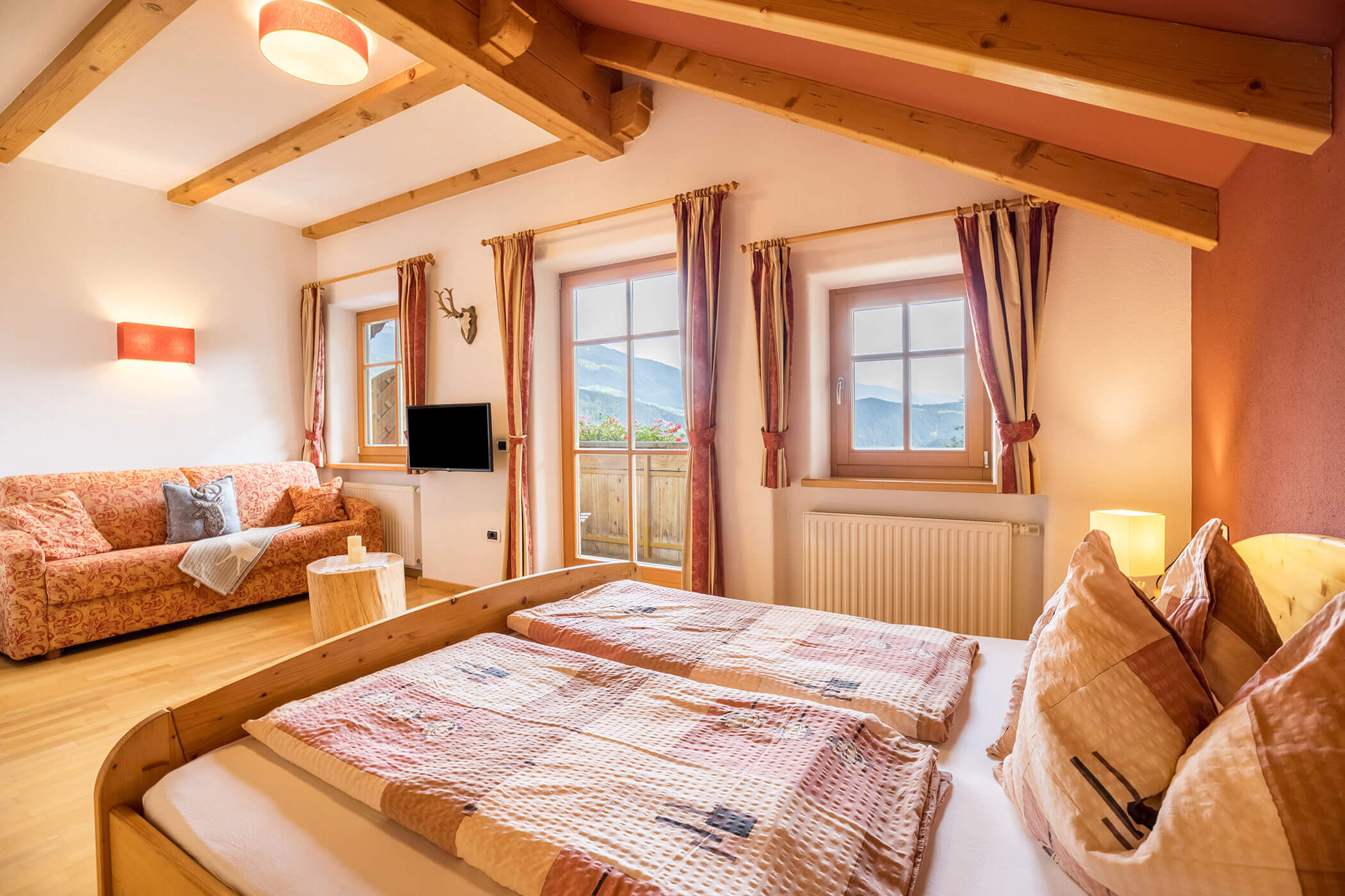 Schlafzimmer im Apartment Kronplatz mit Doppelbett und einem Sofa - Oberplunerhof