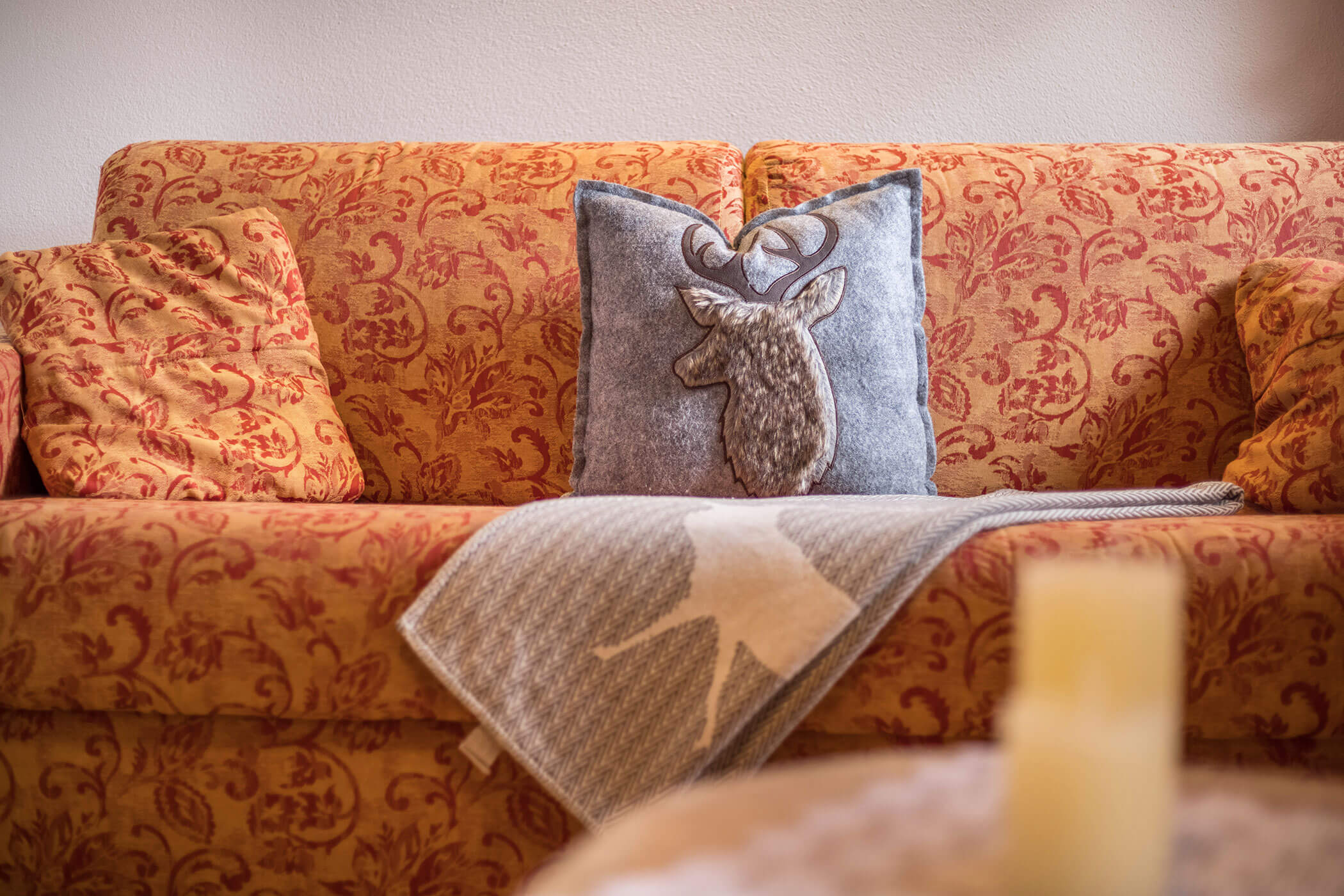 Sofa im Schlafzimmer vom Apartment Kronplatz mit drei Kissen und einer Decke - Oberplunerhof