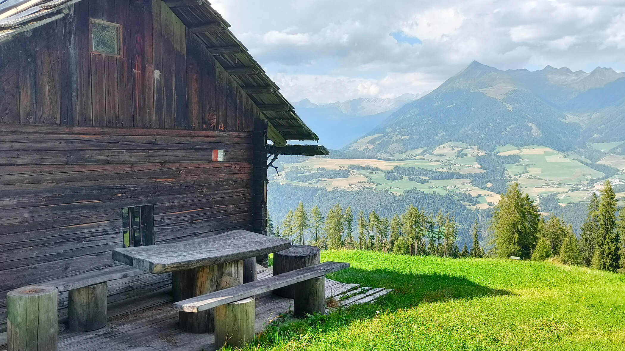 Almhütte mit Holztisch- und Bänken mit tollem Ausblick auf die Südtiroler Bergwelt - Oberplunerhof
