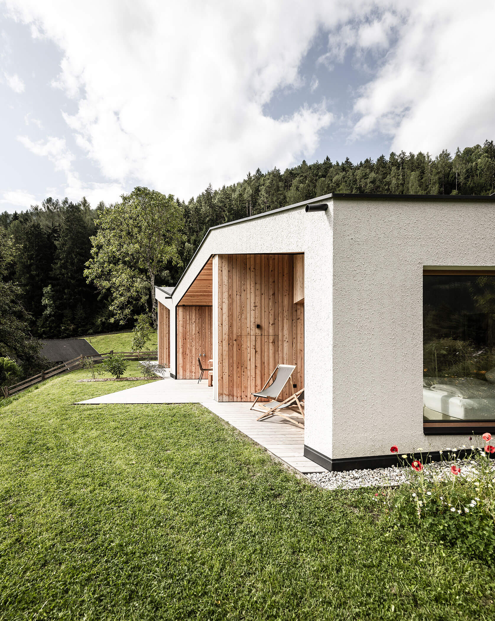 Die Chalets des Oberplunerhofs mit Terrasse und Liegestühlen