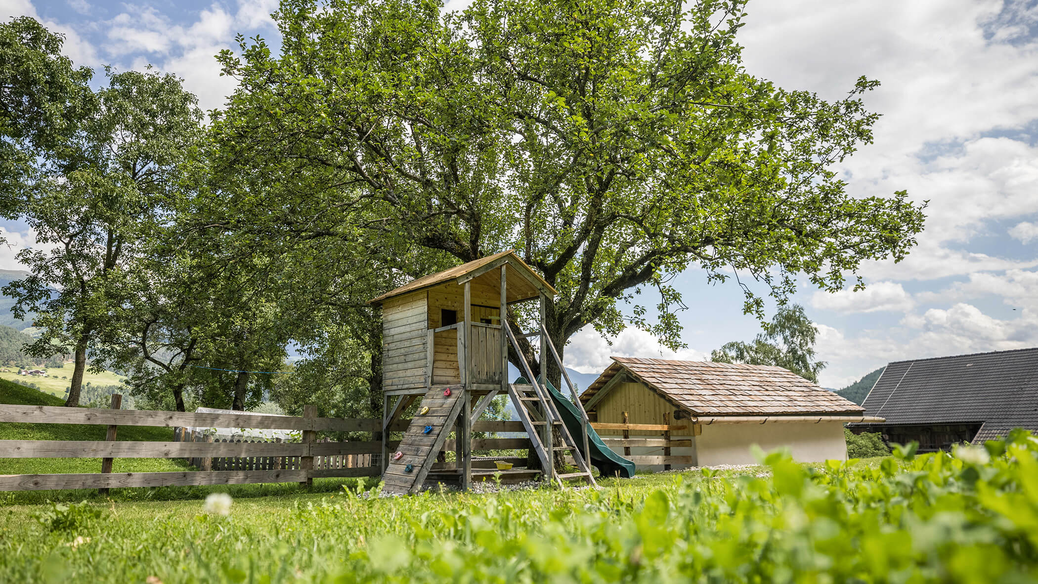 Baumhaus mit Klettermöglichkeiten und einer Rutsche - Oberplunerhof