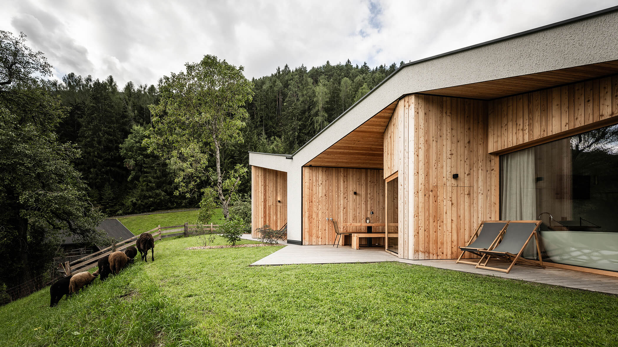 Die Terrassen der Chalet mit Liegestühlen, Sauna und Sitzmöglichkeiten - Oberplunerhof