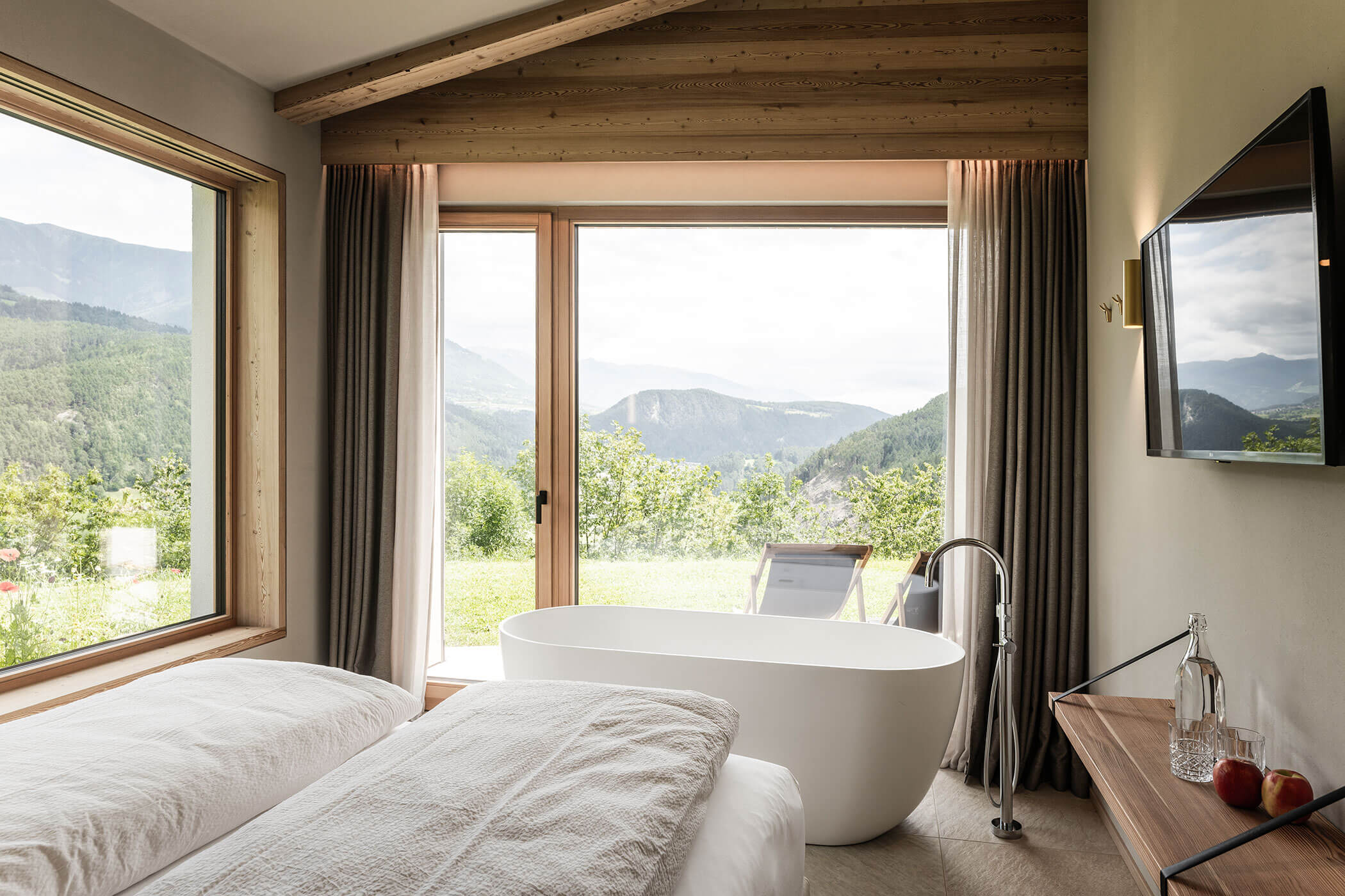 Zimmer im Chalet Skyline mit Doppelbett, freistehendes Badewanne und Blick auf die Südtiroler Bergwelt - Oberplunerhof