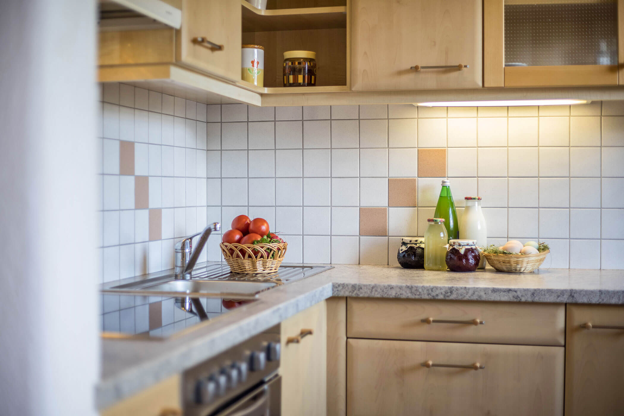 Kochnische im Apartment Gitschberg mit verschiedenen Säften, frischer Milch, Eiern und Äpfeln - Oberpluenrhof
